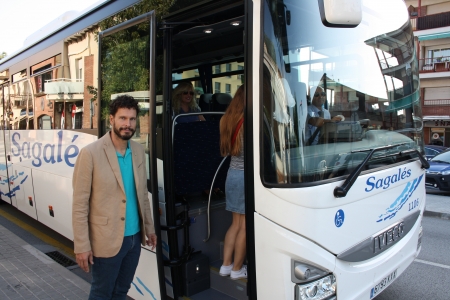 El regidor Jordi Carreras agafant l'e7 a la parada de bus de La Sala