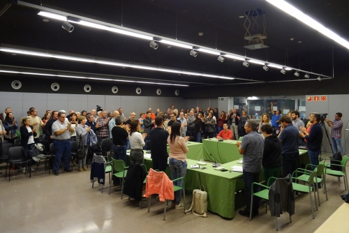 Regidors i públic assistent al ple, aplaudint l'aprovació de la moció