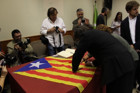 Signant una estelada a l'ex sala de plens de l'Ajuntament