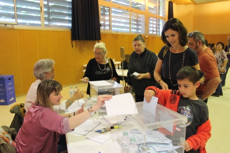 Un nen dipositant la butlleta dins de l'urna